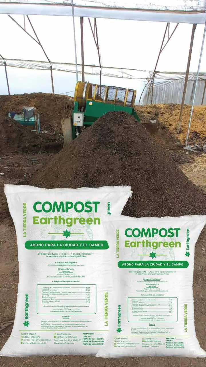 Bolsas de Compost Earthgreen apiladas junto a una pila de compost