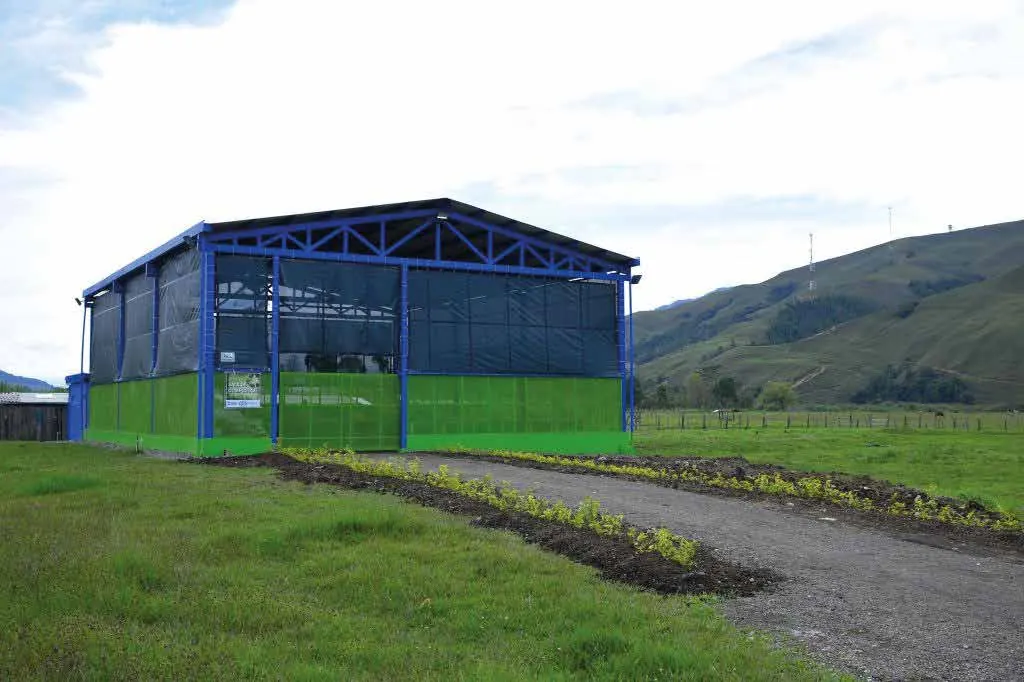 Galpón azul de la planta de compostaje de Urrao en un valle verde